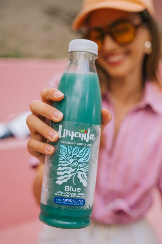 Žena držiaca fľašu nápoja Limeñita Blue s príchuťou Spirulina, posilňujúci imunitný systém.